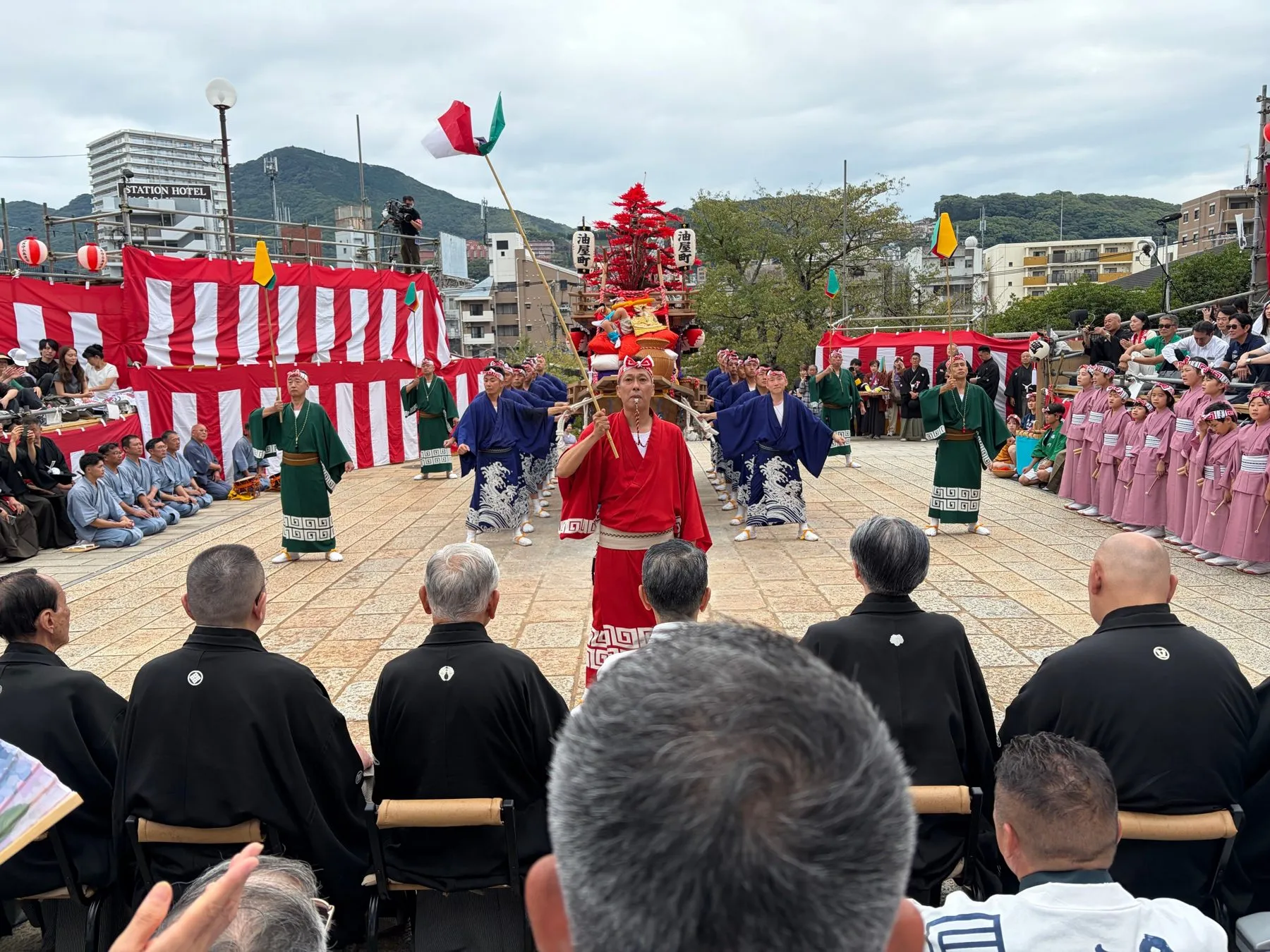 踊場で舞う衣装の人と、並ぶ踊町の人たち