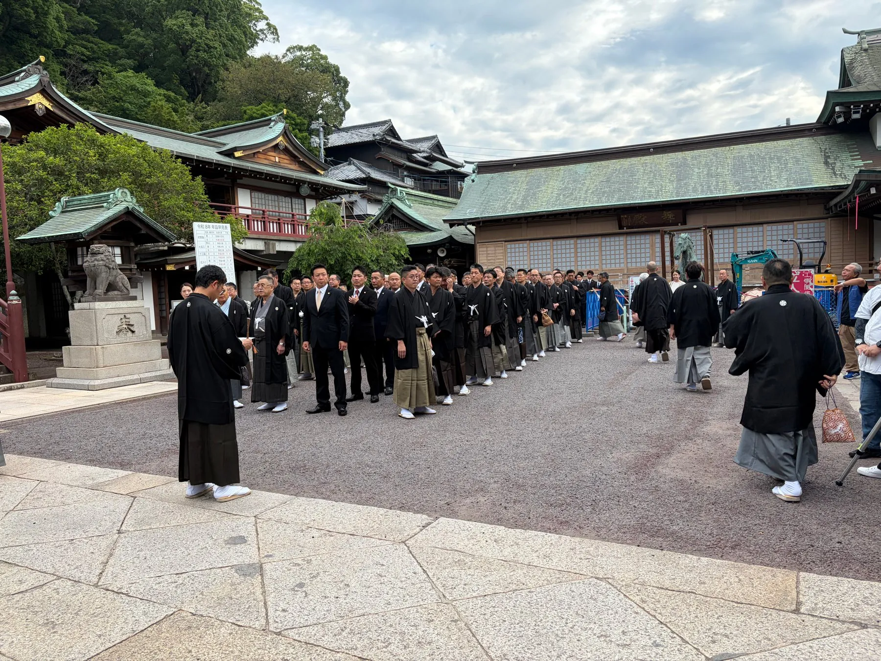 神社の境内に並ぶ紋付袴の人たち