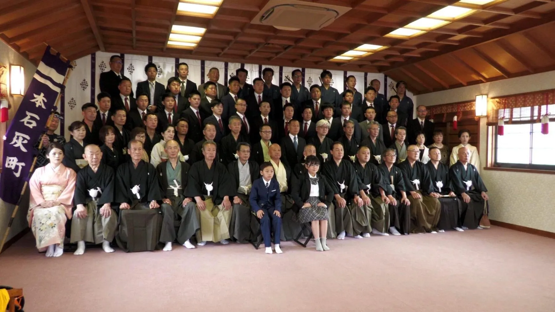 本石灰町の幟の前に並ぶ紋付袴の人たち