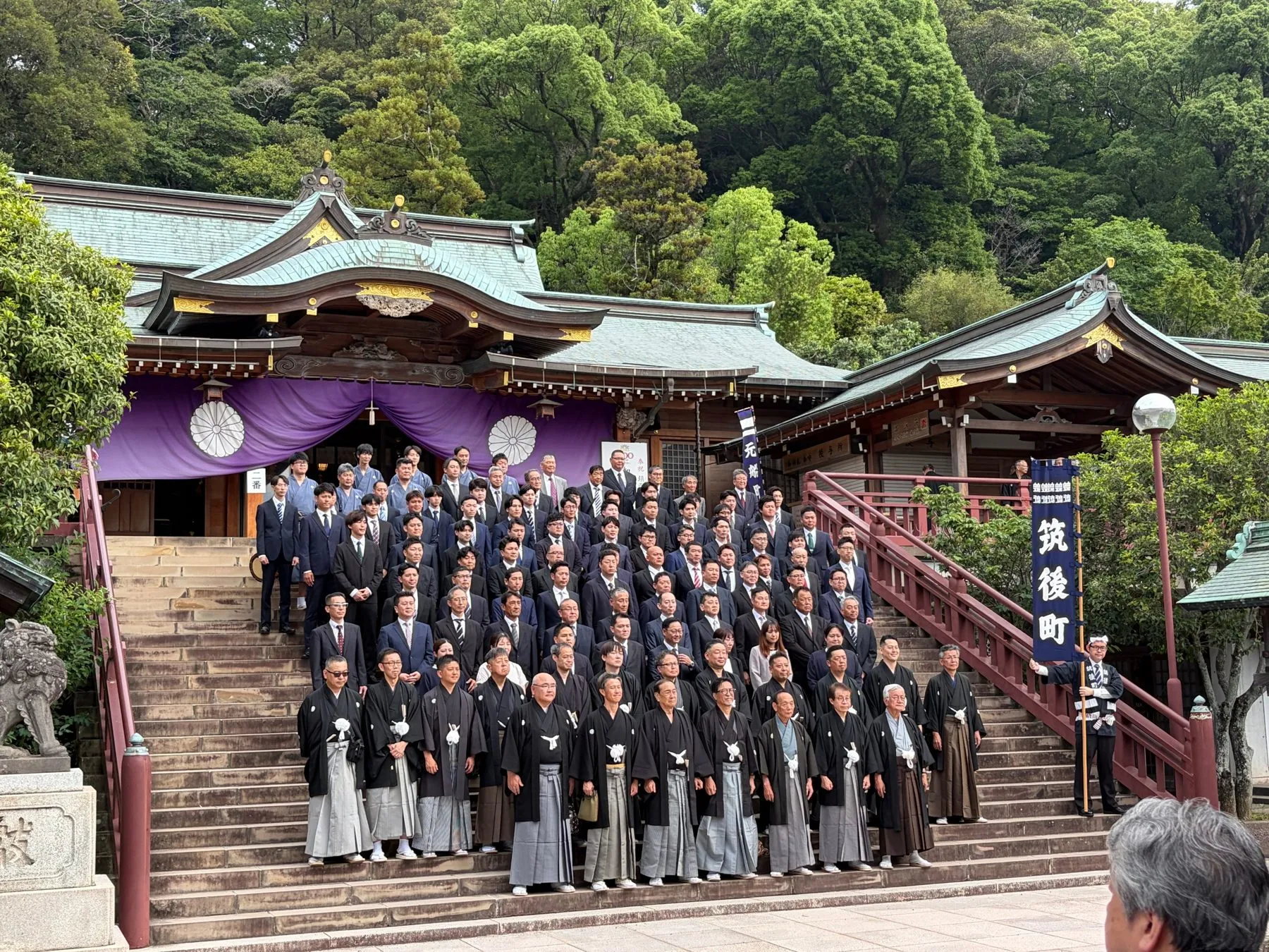 社殿の石段に並んで記念撮影をする筑後町の人たち