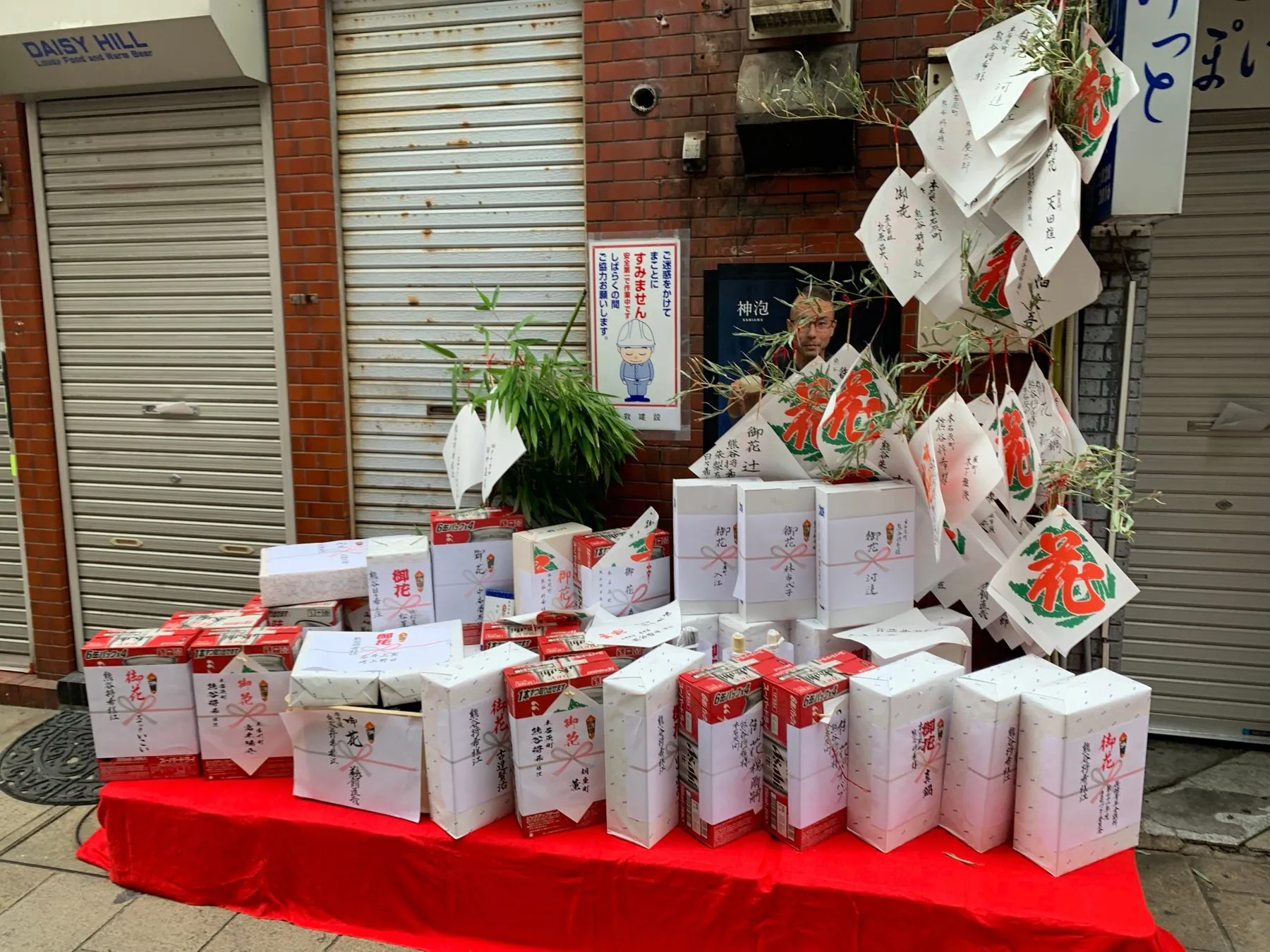 店先に積まれた御花の箱と札