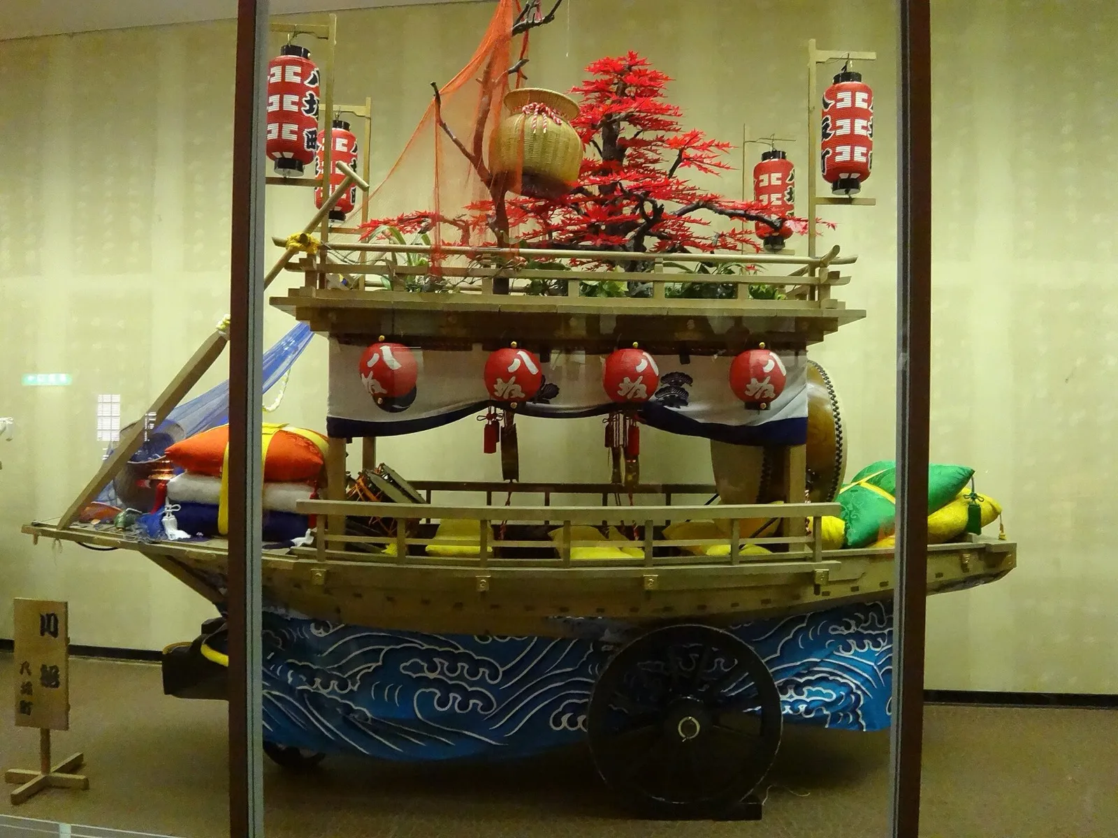 長崎伝統芸能館に展示されていた八坂町の川船（2012年撮影）。「八坂」の提灯と紅葉の飾り、大きな車輪が見える